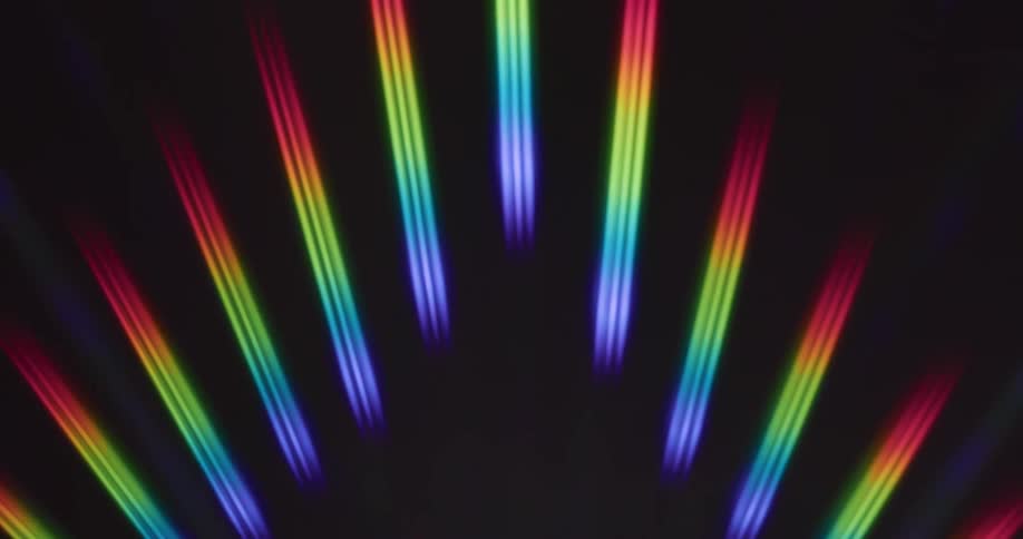 Rainbow colored clusters of laser lights move through the air