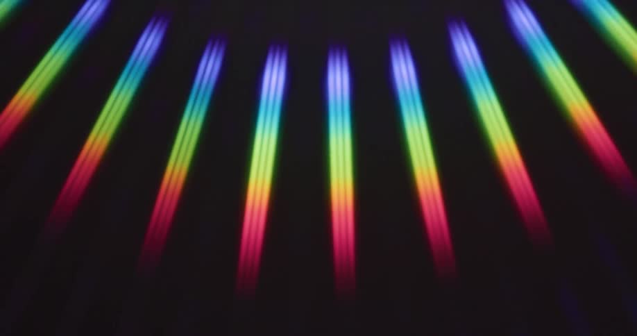 Rainbow rays of light spin on a black surface