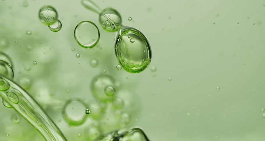 Air bubbles slowly move through a thick green liquid