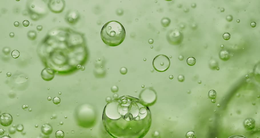 Orbs and bubbles float and move through a clear lime green liquid