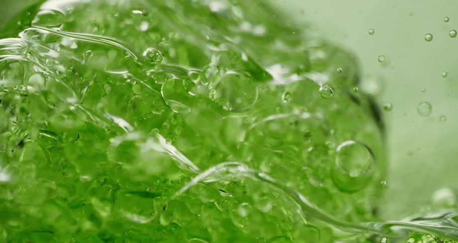 Air bubbles slowly move through a thick green liquid