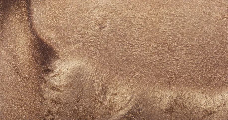 Gold and brown particles flow and ripples