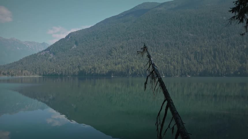 Landscape of a crystalclear lake surrounded by mountains with vegetation