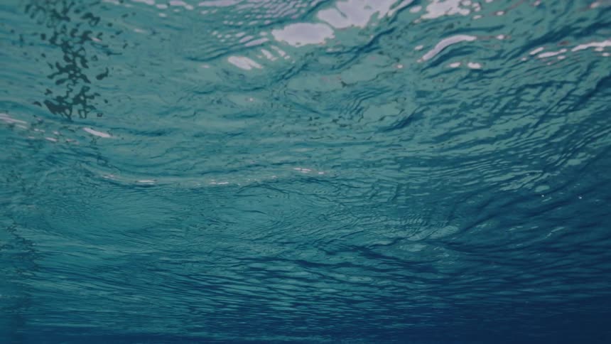 Sunlight shines on clear blue water as it ripples and moves