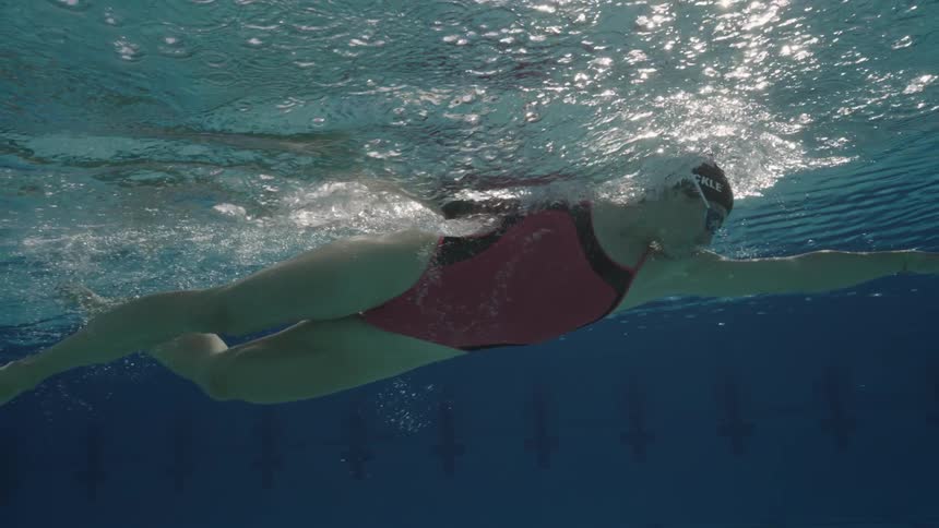 Female athlete swims in an Olympic pool