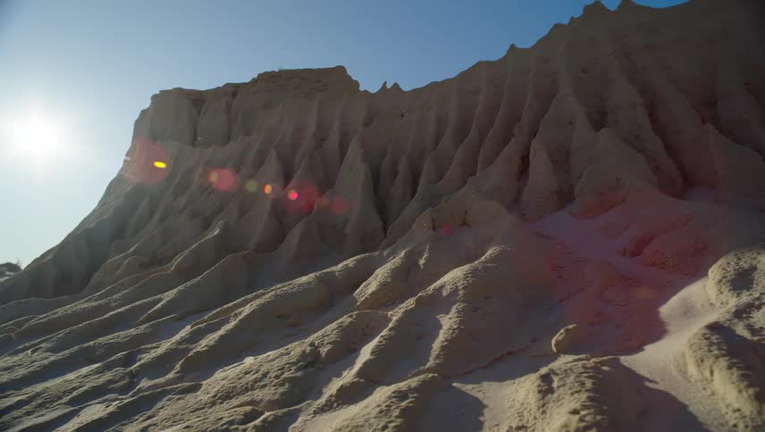 Sun shines over a rock formation in the desert