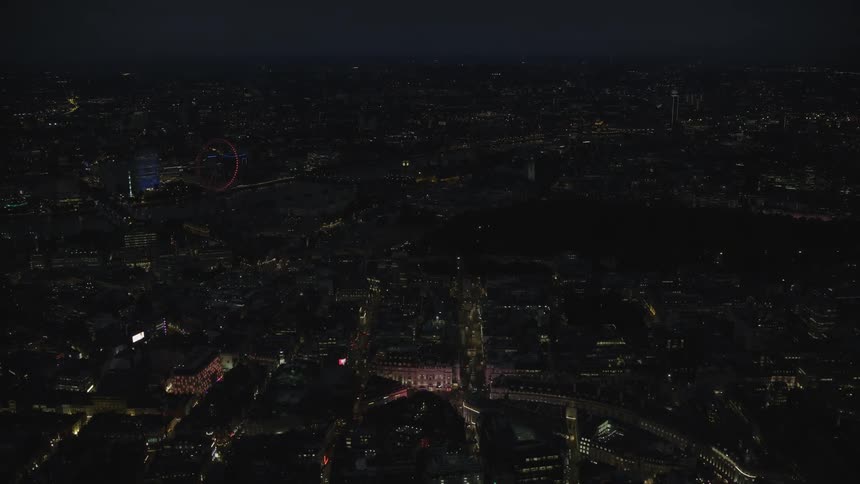 Aerial view of illuminated buildings and ferris wheel in the city at night