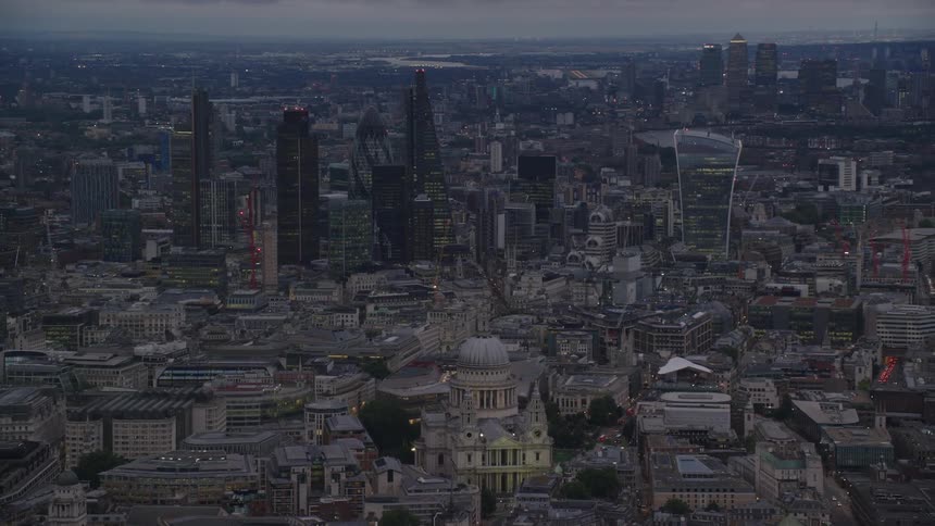 A domed building with beautiful architecture is surrounded by buildings in a crowded city with towers and skyscrapers in the distance