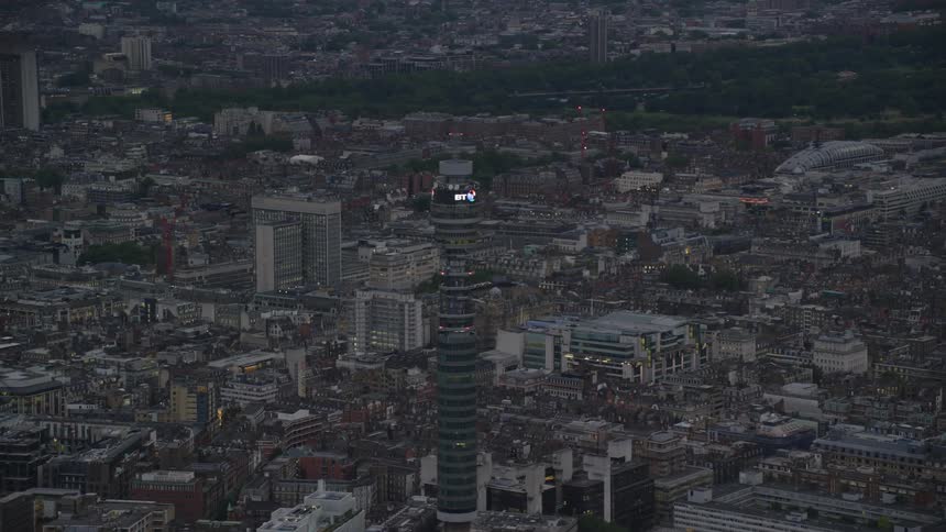 A tall tower overlooks a crowded city with high rise buildings and apartments