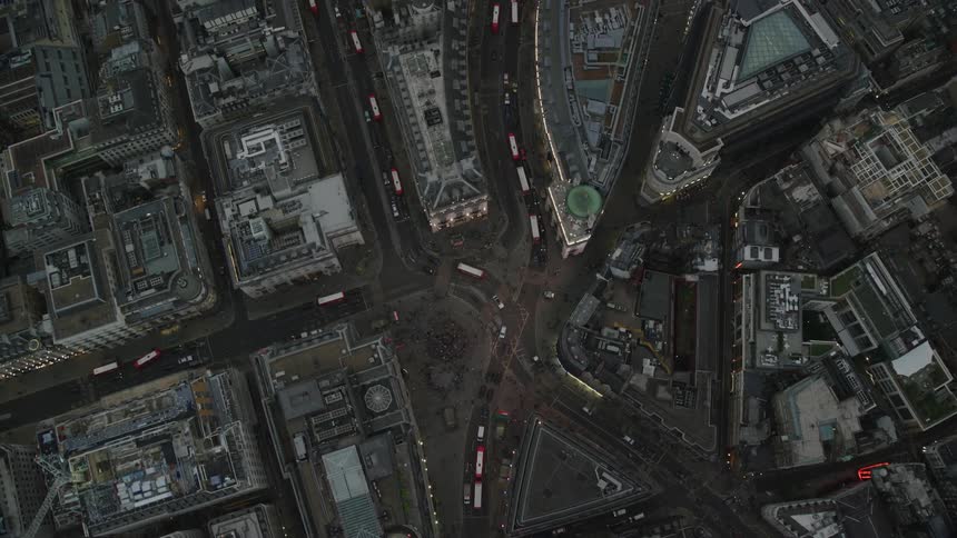 Multiple buses cross through downtown intersection onto curving road