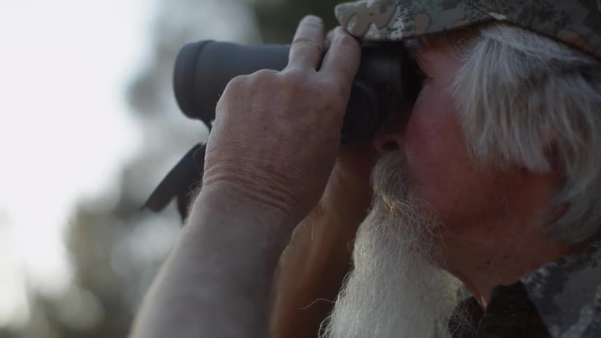 A man is looking through binoculars