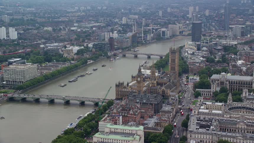 Traffic crosses thames near westminster palace in london on hazy day