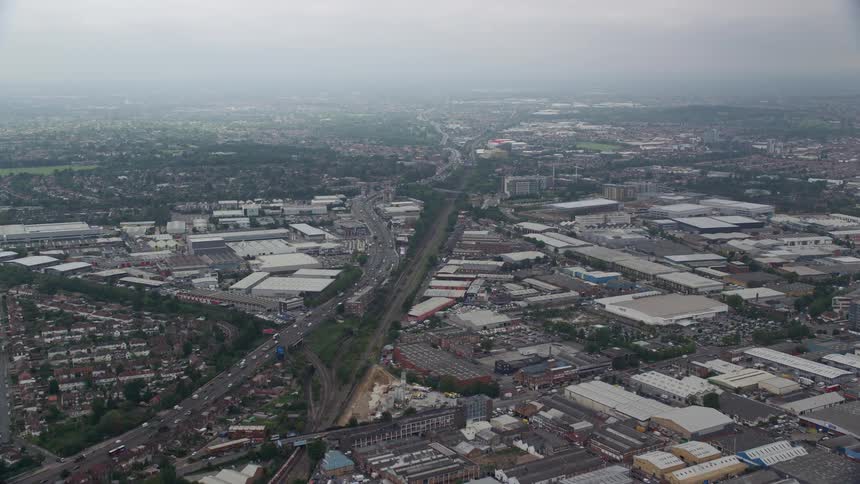 Aerial perspective of a highway stretching towards a city surrounded by buildings of varying architectures and heights