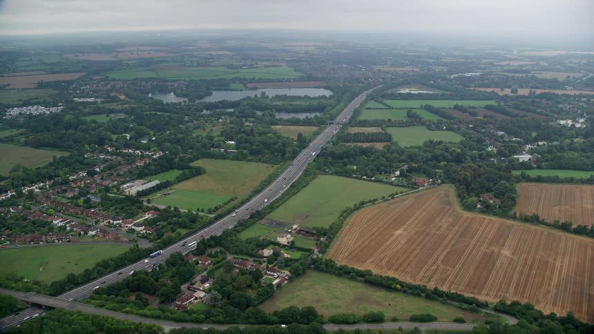 Aerial view of agricultural areas residential neighborhoods rivers and vehicles moving on the roads
