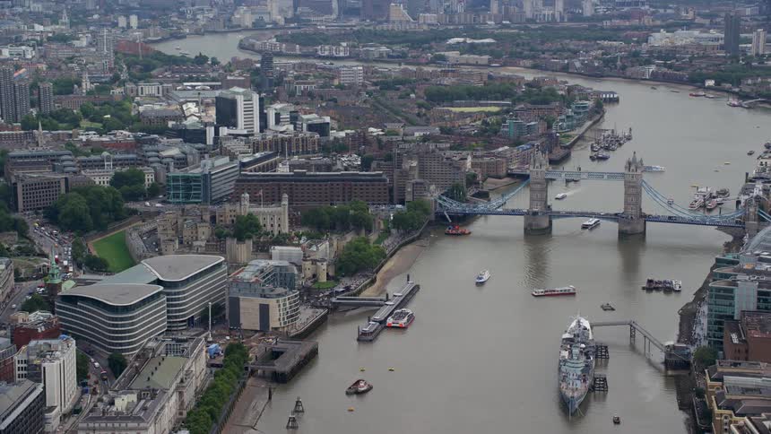 Ships sit at dock near london bridge on foggy day
