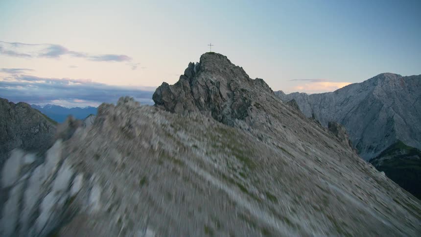 A cross is at the peak of the mountain