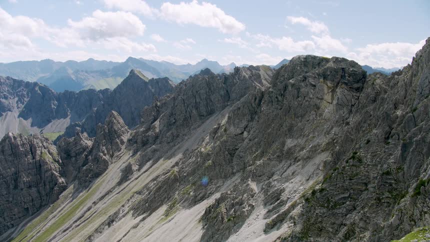 Series of mountain with rough edges at the top and some covered in green grasses