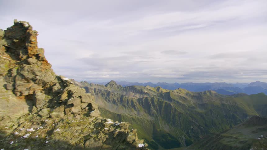 Aerial of snow dusted mountainous terrain on a cloudy day
