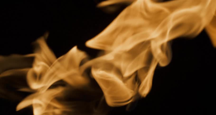 Glowing flames twist and turn as they float across the darkness