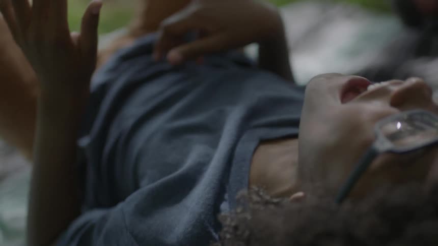A boy rolls around on a blanket laughing