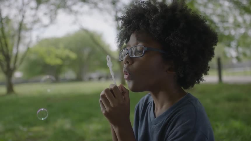 A boy is blowing bubbles