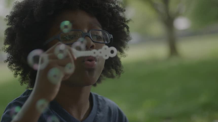 A boy is blowing bubbles