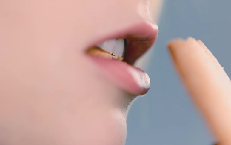 Woman takes a bite from a large cookie