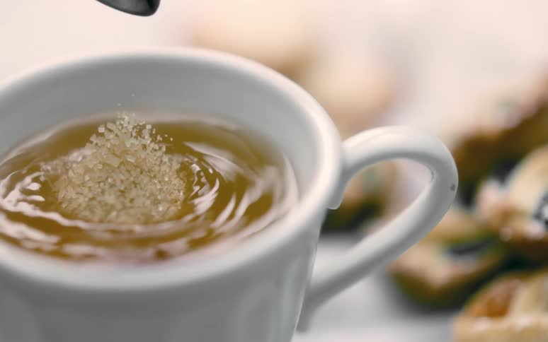 Sugar is poured into the tea