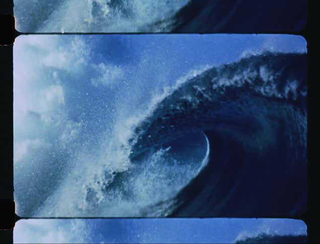 A big waves splashes as it curls and rolls into shore
