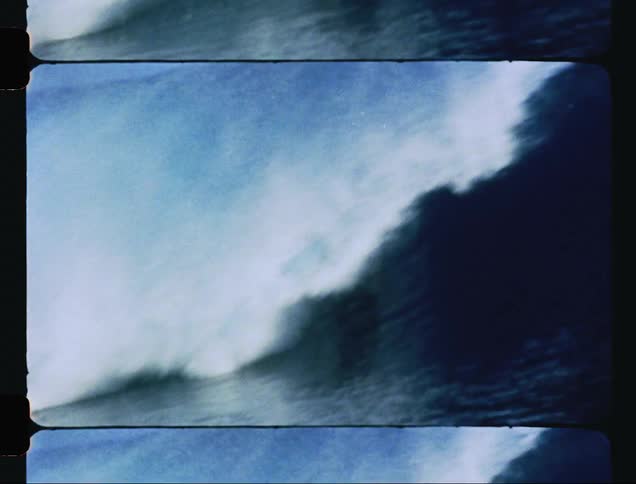 A man surfs a huge ocean wave and gets knocked off his surfboard