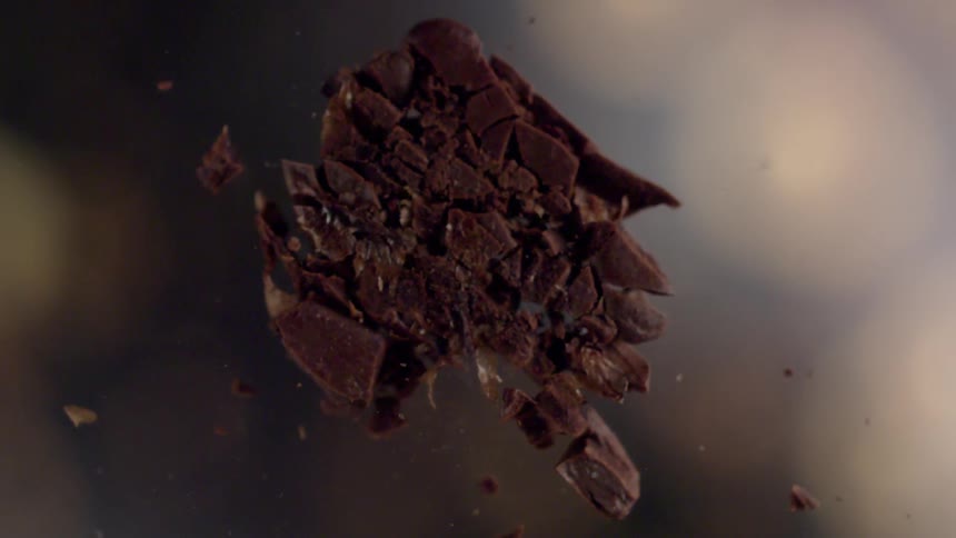 A brown candy exploding into several smaller pieces