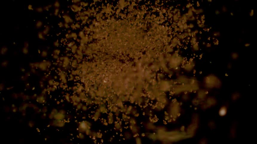 Several golden particles going towards the center in reverse