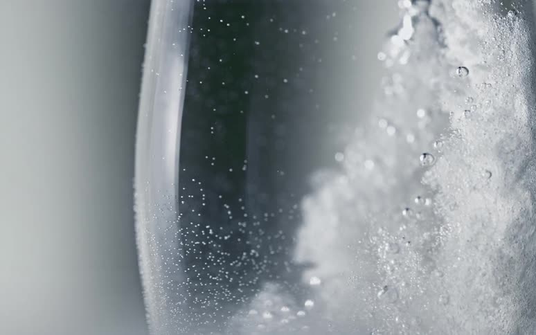 Sudsy foamy water rotates in the window of a washing machine
