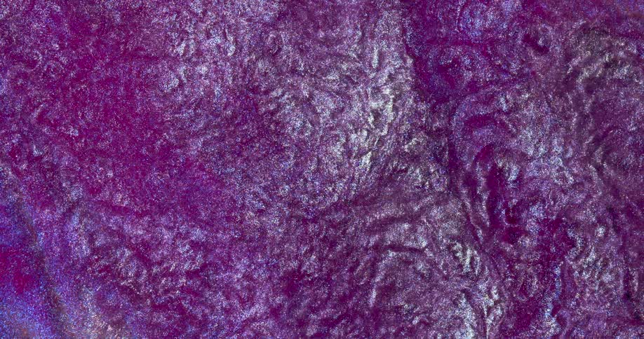 Moving liquid glitter inks creating a wavy metallic abstract background