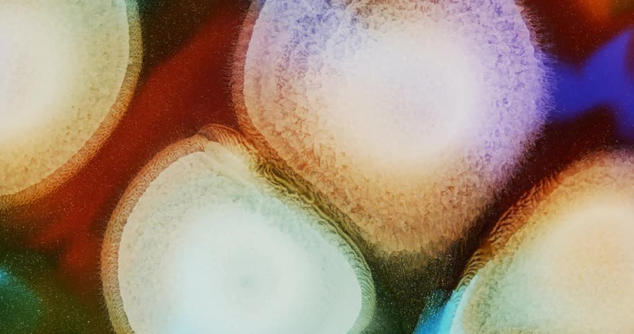 Expanding circles of abstract pearlescent ink drops flowing background
