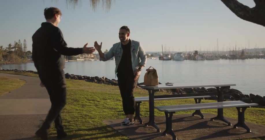 Two men greet each other by the lake