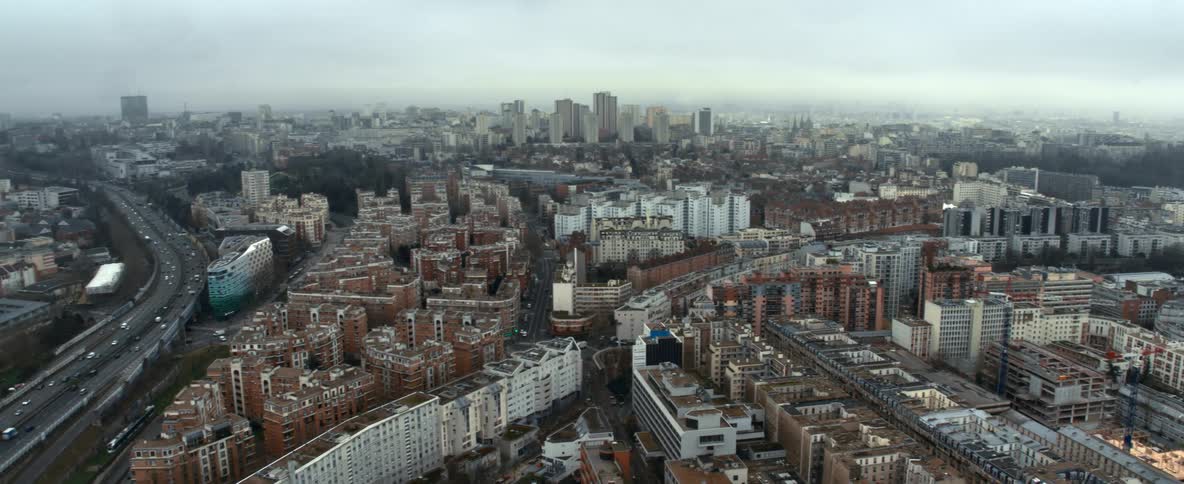 Crowded city filled with buildings close together as traffic moves on highways through town with tall buildings and skyscrapers on the skyline in the distance