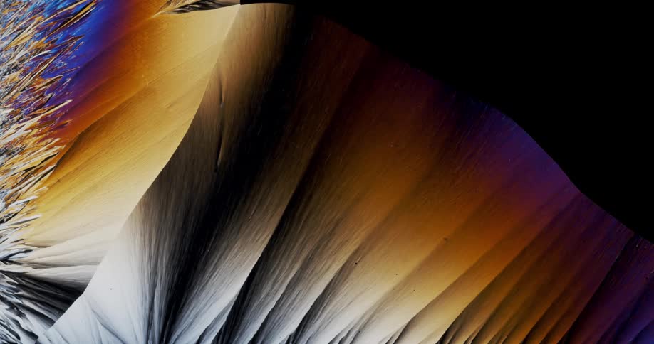 Smoothly growing crystals of liquid chemical watched with microscope