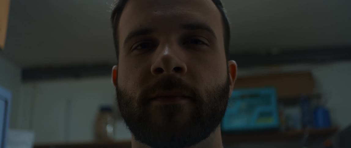 A face of a man with a beard and he looks forward