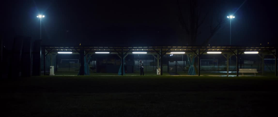 A person practices golf at night