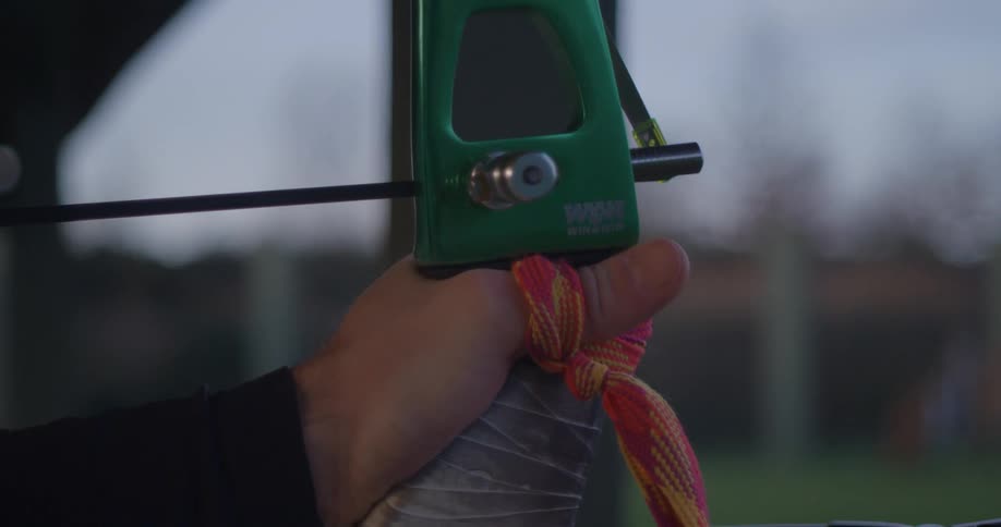 Closeup of a persons hands holding a bow and arrow in position