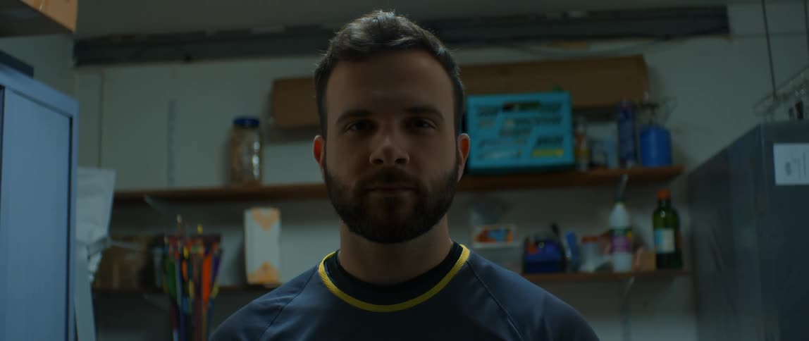 A bearded man staring straight ahead