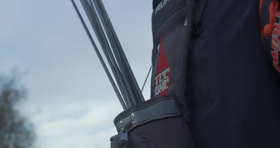 A man pulls and arrow out of the quiver on a cloudy day