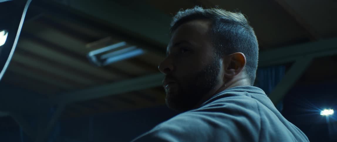 A bearded man shoots an arrow as part of his archery practice