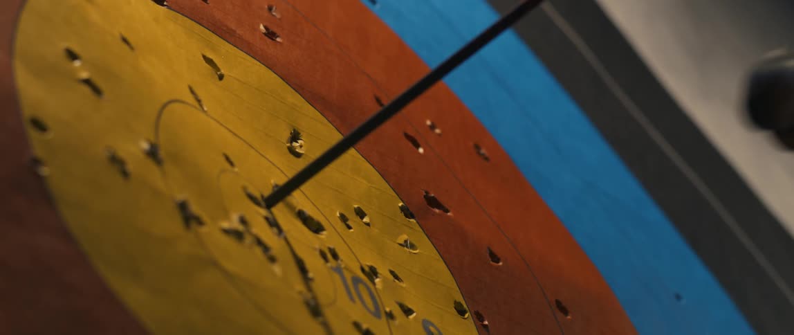 Archer holding a bow pulls an arrow from the target