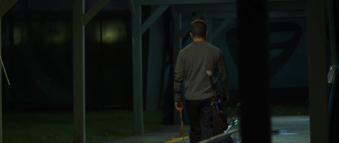 A man carries tools through the dark room