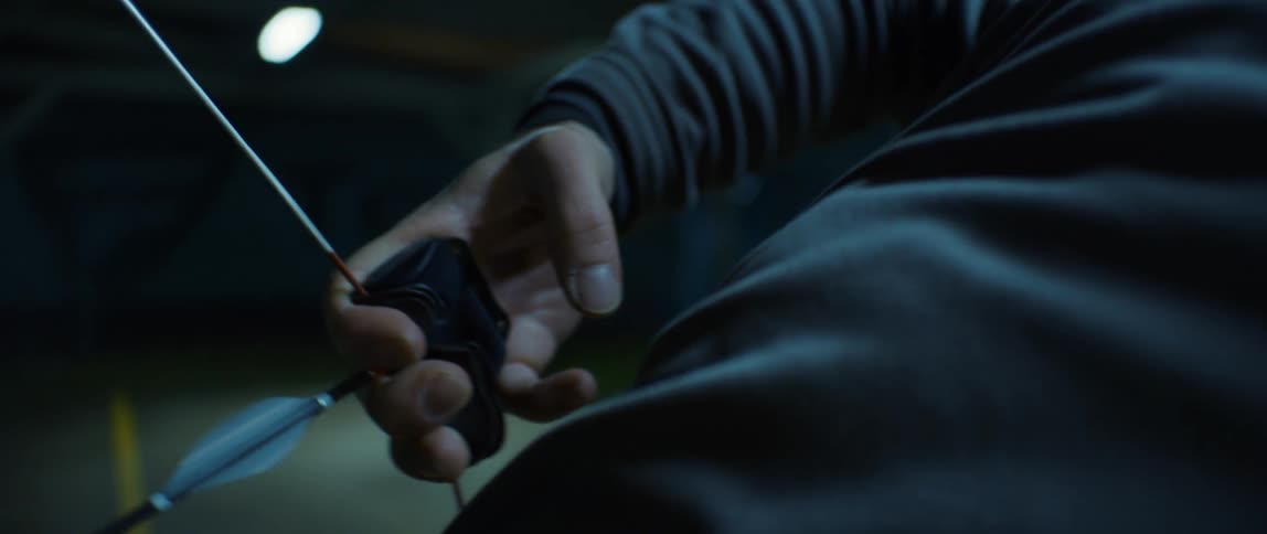 Archer prepares to make a shot with bow and arrow at night