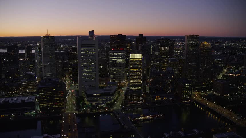 An aerial of a river and skyscrapers in an urban area at dusk