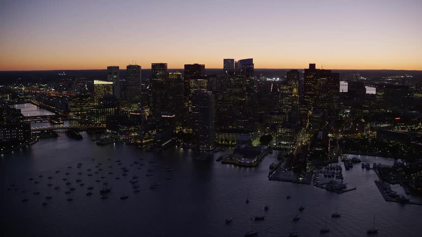 An aerial view of a lake and a city lit up at sunset