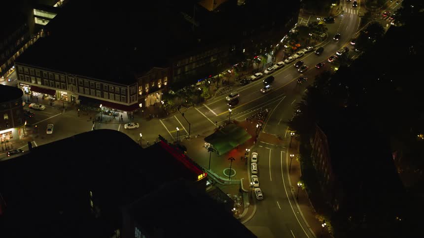An intersection of streets where cars pass at night in a city